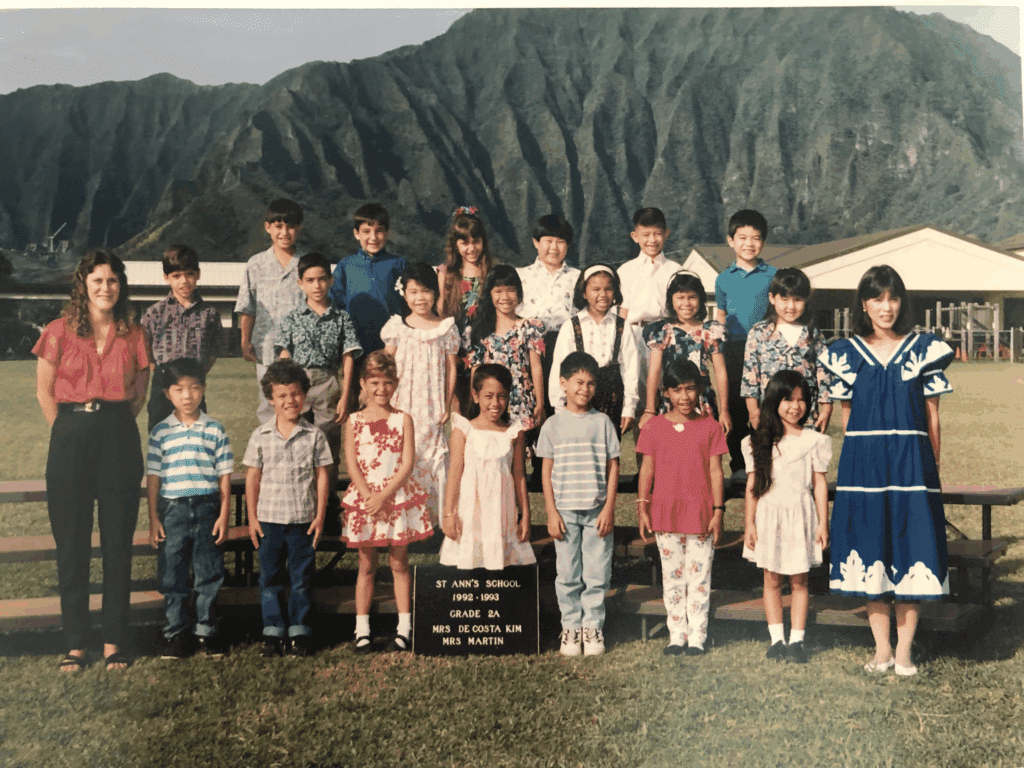 Private school children line up for a school photo with the Koolau Mountains behind them