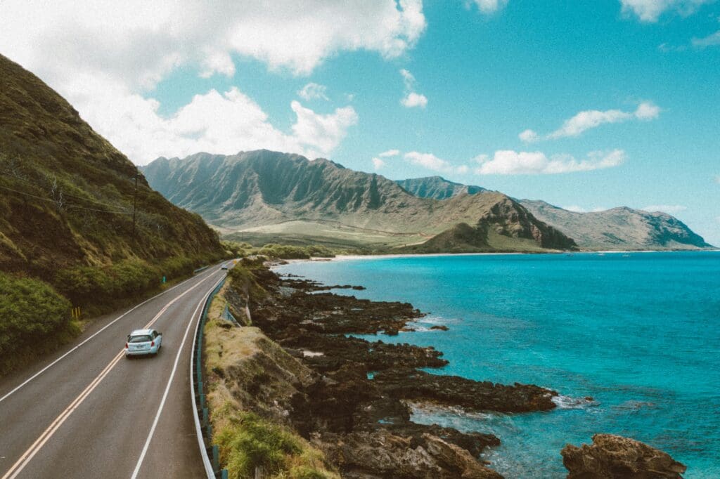 Car driving along scenic road in Hawai'i
